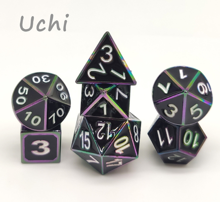 Mano robusta che versa gli insiemi colorati dei dadi, dadi Polyhedral unici del metallo