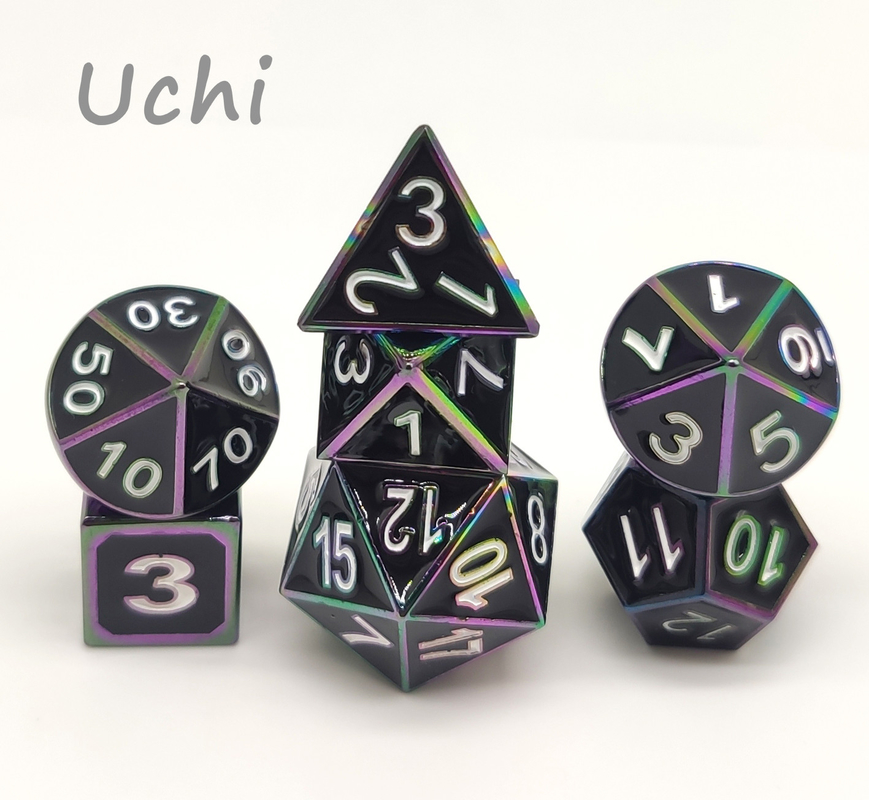 Mano robusta che versa gli insiemi colorati dei dadi, dadi Polyhedral unici del metallo